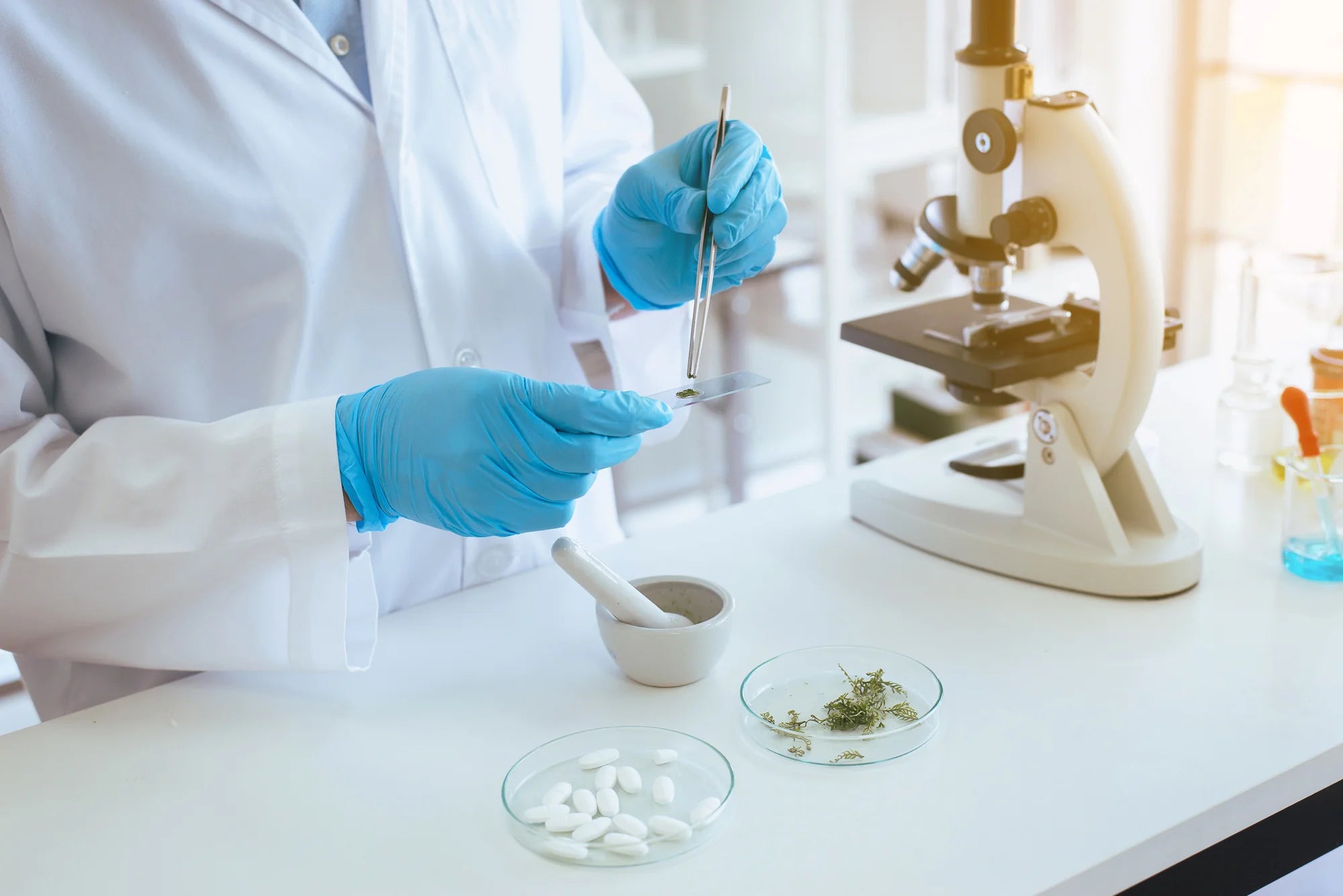 Photo of scientist in a lab working with ingredients by a microscope